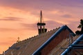 A roof truss of a new building with a topping-out wreath at sunset