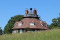 The roof of an unusual historic sixteen sided house on a beautiful sunny summers day in Devon, England seen from across the meadow Royalty Free Stock Photo