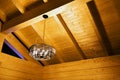 The roof of a wooden house. Inside view of the ceiling with a bright chandelier