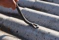 Roof worker repair dangerous asbestos old roof tiles.