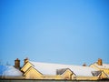 Roof of a yellow house covered with snow and clean blue sky. Beautiful winter day concept. Cold season time. Nobody Royalty Free Stock Photo