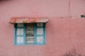 Roofed window with closed wooden shutter - colorful building ext