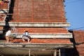 Roofer assembling tiles to the top of the unfinished temple roof