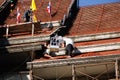 Roofer assembling tiles to the top of the unfinished temple roof