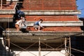 Roofer assembling tiles to the top of the unfinished temple roof