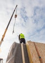 Roofer builder worker with crane installing structural Insulated Panels SIP. Building new frame energy-efficient house. Royalty Free Stock Photo