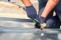 Roofer builder worker finishing folding a metal sheet using rubber mallet Royalty Free Stock Photo