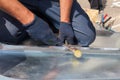 Roofer builder worker finishing folding a metal sheet using rubber mallet. Royalty Free Stock Photo