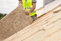 Roofer builder worker installing roof insulation material on new house under construction. Royalty Free Stock Photo