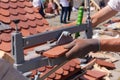 Roofer builder worker use tile cutter to create a correct size of natural red ceramic tile.