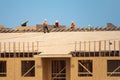 Roofer carpenter working on roof structure on construction site. Roofer on roofing job. Roof on high work place. Workers Royalty Free Stock Photo