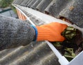 Roofer Cleaning Rain Gutter from Leaves. Roof Gutter Cleaning. House Gutter Cleaning Royalty Free Stock Photo