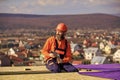 Roofer constructing roof. Man roofing surface. Install partially overlapping layers of material over roof insulation