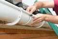 Roofer contractor installing and repair rain gutter pipeline connection Royalty Free Stock Photo