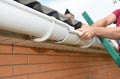 Roofer contractor installing and repair roof gutter. Guttering repair with hands.
