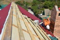 Roofer contractor installing roof with lightweight metal roof tiles in problem area. Steel Tile Roofing Construction on House