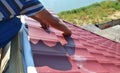 Roofer contractor installing roof with lightweight metal roof tiles. Steel Tile roofing construction house rooftop