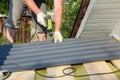 Roofer with crew gun installing metal roof tiles. Roofing construction with roofing contractor laying metal roof sheets Royalty Free Stock Photo