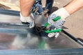 Roofer folding a metal sheet using special pliers with a large flat grip. Royalty Free Stock Photo