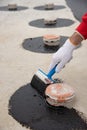 Worker applies bitumen mastic on the foundation