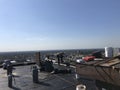 Roofer and a crew working on a smooth modified flat roof, roofing project in progress