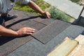 Roofer installing asphalt shingles on house construction roof corner. Roofing construction.