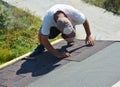 Roofer installing Asphalt Shingles on house construction roof. Shingles roofing construction