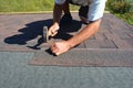Roofer installing Asphalt Shingles on house Roofing Construction with hammer and nails in motion Royalty Free Stock Photo