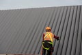 Roofer installing metal sheet on the construction site