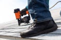 Roofer installing roof shingles with nail gun