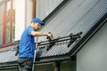Roofer installing snow guard on metal roof