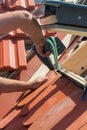 Roofer installs a skylight on the new roof using a drill. Royalty Free Stock Photo