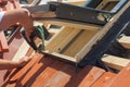 Roofer installs a skylight on the new roof using a drill. Royalty Free Stock Photo