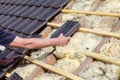 A roofer laying tile on the roof