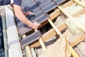 A roofer laying tile on the roof