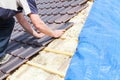 A roofer laying tile on the roof