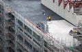 Roofer painting flat roof of a commercial building. Royalty Free Stock Photo