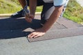 Roofer repair, renovating, installing asphalt shingles on house roofing construction with hammer and nails in action. Roof repair