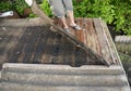 Roofer repair and renovation old asbestos roof. Old house roof with bad wet wooden beams. Roofing construction