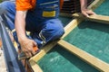 A roofer on the rooftop prepairing wooden construction. Royalty Free Stock Photo