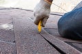 Roofer worker cuts shingles on the roof.