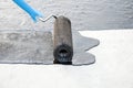 Roofer worker painting bitumen praimer at concrete surface by t