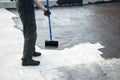 Roofer worker painting bitumen praimer at concrete surface by t