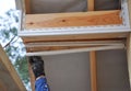 Roofer worker uses a hand to install soffit, eaves, wooden beams.