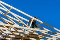 Roofer working with framing installing the roof truss system