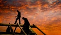 Roofers build cabin roof at dusk