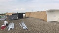 Roofers and a crew repairing a commercial flat roof and materials, tools and supplies Royalty Free Stock Photo