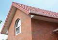 Roofing Construction. Attic brick house roof construction with ceramic clay roof tiles and rain gutter.