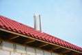 Roofing Construction Exterior. Building new house with metal red roof and steel chimney outdoor. Soffit and Fascia unfinished inst Royalty Free Stock Photo