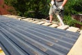 Roofing construction: a roofer is cutting with an electric saw roof sheathing boards making the roof edge even before a Royalty Free Stock Photo